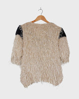 Cuddle up in this 90s vintage sweater, featuring a furry beige and dirty white design. The unique 1/2 sleeve style and attached shell add an extra touch of playful charm. We absolutely love this unique sweater! What about you?