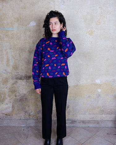 Embrace this eye-catching purple sweater from the 90s. With its unique multi-color pattern, it's sure to bring some pop of personality to your outfit.