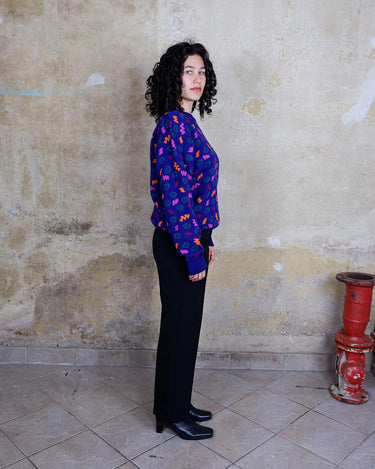 Embrace this eye-catching purple sweater from the 90s. With its unique multi-color pattern, it's sure to bring some pop of personality to your outfit.
