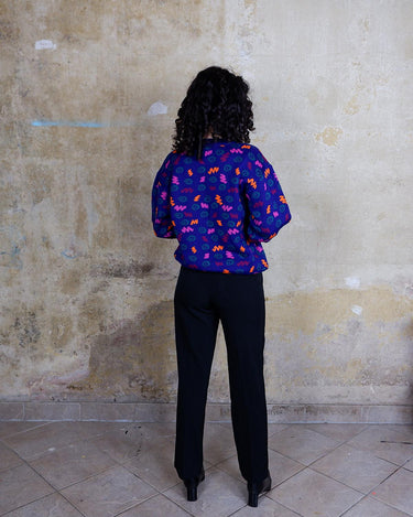 Embrace this eye-catching purple sweater from the 90s. With its unique multi-color pattern, it's sure to bring some pop of personality to your outfit.