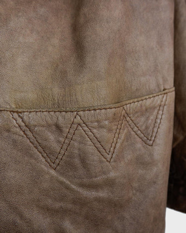 Introducing our must-have Vintage 80s brown/beige leather jacket (used look). It features shoulder pads for a structured look and adds a touch of 80s style to any wardrobe.
