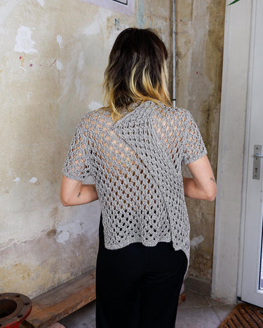 Preloved and handmade, this silver crochet top catches the light with its soft shimmer. The open-knit design and asymmetrical cut give it that effortless, worn-in feel. A rare find that’s easy to style and full of character.
