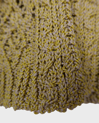 Add some playful personality to your wardrobe with this handmade beige and shimmering yellow cardigan. The light crop fit makes it perfect for layering over any outfit.