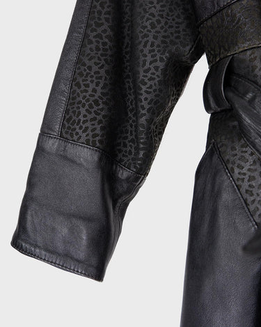 This vintage 80s coat features a fierce black animal print, adding a unique touch to any outfit. The belted waist cinches in for a flattering fit, making you feel confident and channeling your inner wild side.
