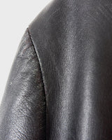 Introducing our Vintage 90s black long leather button coat! Timeless, sleek, and classic, this coat is the perfect addition to any wardrobe. Featuring a button closure, it exudes elegance.