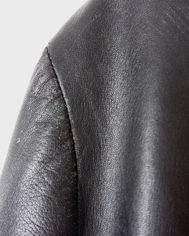 Introducing our Vintage 90s black long leather button coat! Timeless, sleek, and classic, this coat is the perfect addition to any wardrobe. Featuring a button closure, it exudes elegance.