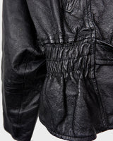 Unleash your inner badass with this Vintage 80s black biker leather jacket. The edgy look is complete with a belted waist and light shoulder pads, making it the perfect statement piece for spring. Crafted from light leather, it provides style and comfort.