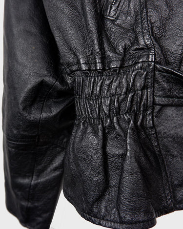 Unleash your inner badass with this Vintage 80s black biker leather jacket. The edgy look is complete with a belted waist and light shoulder pads, making it the perfect statement piece for spring. Crafted from light leather, it provides style and comfort.