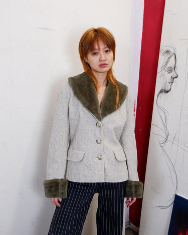 Embrace timeless style with this vintage grey/beige jacket, complete with a cozy faux fur collar. Stay warm and on-trend in this unique statement piece. And as if its classic style isn't enough, it comes with a fuzzy faux fur collar for an added touch of coziness (and cuteness).