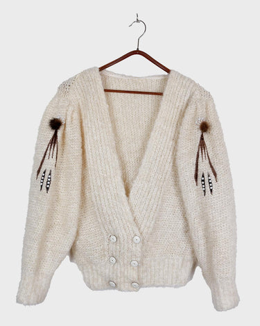Get ready to cozy up with this vintage 80s boho-style cardigan! Crafted from a mohair mix, this playful cardigan features real fur balls for a unique twist