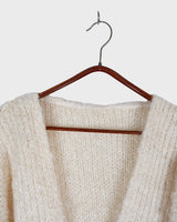Get ready to cozy up with this vintage 80s boho-style cardigan! Crafted from a mohair mix, this playful cardigan features real fur balls for a unique twist