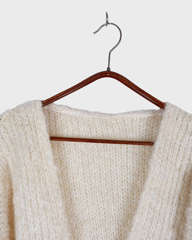 Get ready to cozy up with this vintage 80s boho-style cardigan! Crafted from a mohair mix, this playful cardigan features real fur balls for a unique twist