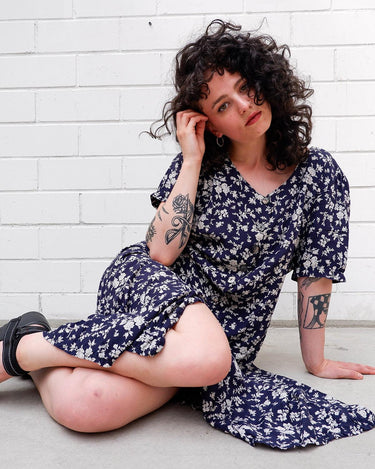 Dress to impress in this vintage 90s blue midi dress with a floral pattern! Tie it tighter for an S-M fit or let it go for a L-XL! Get yours now and get dressed to express!