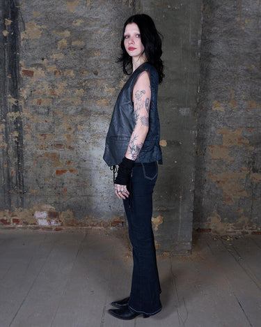 Rock your vintage style with our 90s grey leather vest! This unique piece features a playful paisley pattern at the back for a touch of fun.