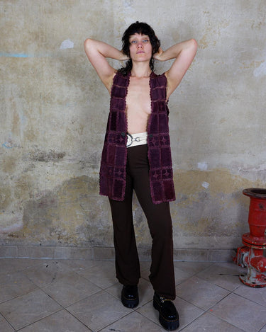 This burgundy leather vest is a vintage gem from the 80s, featuring unique stitching flowers and a boho-style cut. With no closure, it's perfect for layering over any outfit!