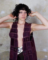 This burgundy leather vest is a vintage gem from the 80s, featuring unique stitching flowers and a boho-style cut. With no closure, it's perfect for layering over any outfit!