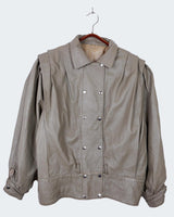 This Vintage 80s grey two row button leather jacket (thin material so perfect for spring) with its light brown undertone is a true timeless piece. From the two row button design to the leather material, this jacket is the perfect piece to embrace the classic look.