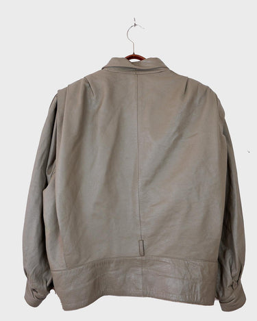 This Vintage 80s grey two row button leather jacket (thin material so perfect for spring) with its light brown undertone is a true timeless piece. From the two row button design to the leather material, this jacket is the perfect piece to embrace the classic look.