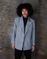 Give your wardrobe an edge with this grey spring double row buttons blazer from the 80s! With subtle yet stylish shoulder pads and a thin design, this blazer will add a touch of timeless vintage charm to any outfit.