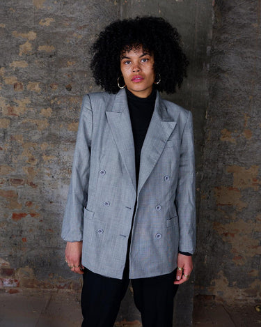 Give your wardrobe an edge with this grey spring double row buttons blazer from the 80s! With subtle yet stylish shoulder pads and a thin design, this blazer will add a touch of timeless vintage charm to any outfit.