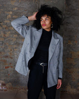 Give your wardrobe an edge with this grey spring double row buttons blazer from the 80s! With subtle yet stylish shoulder pads and a thin design, this blazer will add a touch of timeless vintage charm to any outfit.