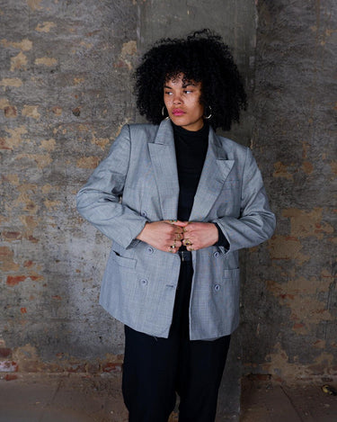 Give your wardrobe an edge with this grey spring double row buttons blazer from the 80s! With subtle yet stylish shoulder pads and a thin design, this blazer will add a touch of timeless vintage charm to any outfit.