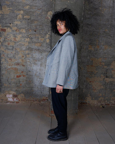 Give your wardrobe an edge with this grey spring double row buttons blazer from the 80s! With subtle yet stylish shoulder pads and a thin design, this blazer will add a touch of timeless vintage charm to any outfit.