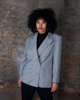 Give your wardrobe an edge with this grey spring double row buttons blazer from the 80s! With subtle yet stylish shoulder pads and a thin design, this blazer will add a touch of timeless vintage charm to any outfit.