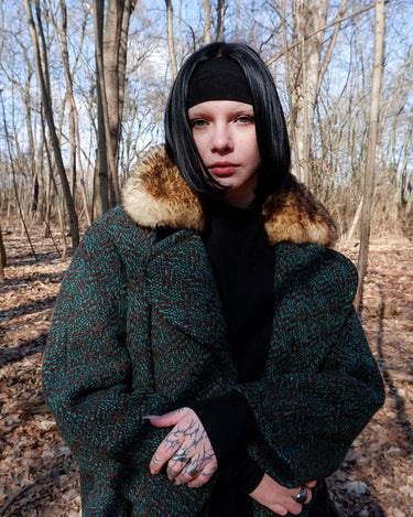 Experience true vintage elegance with this stunning green wool coat from the 70s/80s. Beautiful brown accents add a stylish touch, while the real fur collar adds a luxurious and statement-making element.
