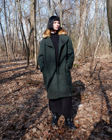 Experience true vintage elegance with this stunning green wool coat from the 70s/80s. Beautiful brown accents add a stylish touch, while the real fur collar adds a luxurious and statement-making element.
