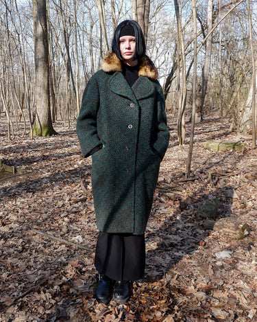 Experience true vintage elegance with this stunning green wool coat from the 70s/80s. Beautiful brown accents add a stylish touch, while the real fur collar adds a luxurious and statement-making element.