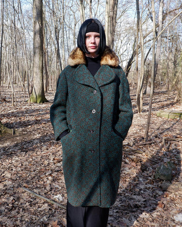 Experience true vintage elegance with this stunning green wool coat from the 70s/80s. Beautiful brown accents add a stylish touch, while the real fur collar adds a luxurious and statement-making element.