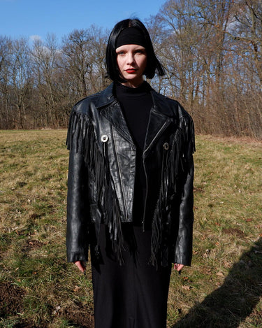 Add some wild vibes to your wardrobe with this vintage 80s 90s black fringe leather jacket. Complete with conchos and a belt, this jacket will be a statement piece for any outfit.
