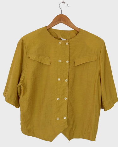 This Vintage 80s yellow short sleeve blouse is a double dose of 80s with its two rows of buttons and shoulder pads!