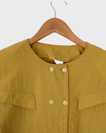 This Vintage 80s yellow short sleeve blouse is a double dose of 80s with its two rows of buttons and shoulder pads!