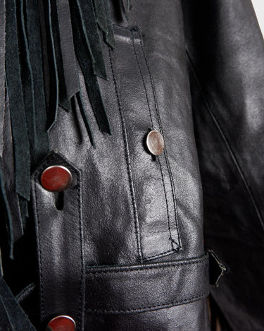Add some wild vibes to your wardrobe with this vintage 80s 90s black fringe leather jacket. Complete with conchos and a belt, this jacket will be a statement piece for any outfit.