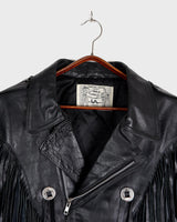 Add some wild vibes to your wardrobe with this vintage 80s 90s black fringe leather jacket. Complete with conchos and a belt, this jacket will be a statement piece for any outfit.