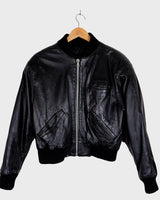This iconic Vintage 80s black bomber leather jacket brings the edge with a serious dose of attitude! Boasting shoulder pads and a classic bomber jacket silhouette, it's sure to unleash your inner wild child!