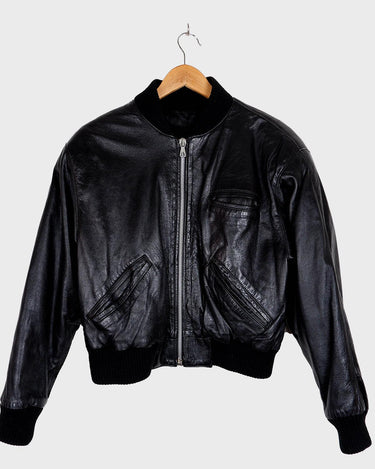 This iconic Vintage 80s black bomber leather jacket brings the edge with a serious dose of attitude! Boasting shoulder pads and a classic bomber jacket silhouette, it's sure to unleash your inner wild child!
