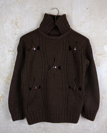 This Vintage 90s brown wool sweater is sure to make a statement with its unique cut outs. Made from high-quality wool, it's perfect for staying cozy while still showing off some skin.