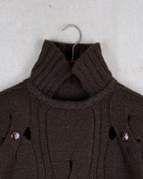This Vintage 90s brown wool sweater is sure to make a statement with its unique cut outs. Made from high-quality wool, it's perfect for staying cozy while still showing off some skin.