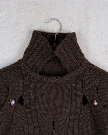 This Vintage 90s brown wool sweater is sure to make a statement with its unique cut outs. Made from high-quality wool, it's perfect for staying cozy while still showing off some skin.