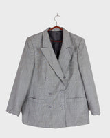 Give your wardrobe an edge with this grey spring double row buttons blazer from the 80s! With subtle yet stylish shoulder pads and a thin design, this blazer will add a touch of timeless vintage charm to any outfit.