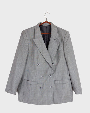 Give your wardrobe an edge with this grey spring double row buttons blazer from the 80s! With subtle yet stylish shoulder pads and a thin design, this blazer will add a touch of timeless vintage charm to any outfit.