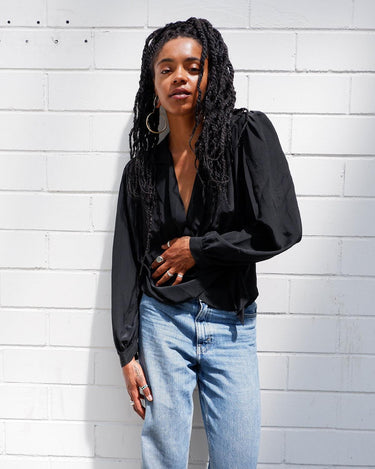 This classic vintage 90s black blouse has got you covered - literally! Wrap yourself up in this silky-smooth garment complete with shoulder pads and a fun floral pattern.