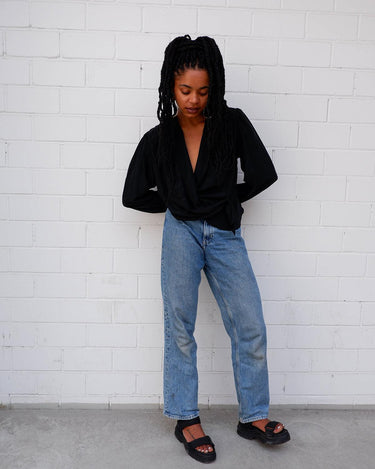 This classic vintage 90s black blouse has got you covered - literally! Wrap yourself up in this silky-smooth garment complete with shoulder pads and a fun floral pattern.