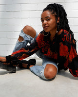 This vintage 80s velvet x silk blouse is having a moment! Its flowy and lightweight transparent fabric, coupled with its stunning red floral pattern, make it a must-have!