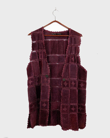 This burgundy leather vest is a vintage gem from the 80s, featuring unique stitching flowers and a boho-style cut. With no closure, it's perfect for layering over any outfit!