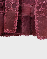 This burgundy leather vest is a vintage gem from the 80s, featuring unique stitching flowers and a boho-style cut. With no closure, it's perfect for layering over any outfit!