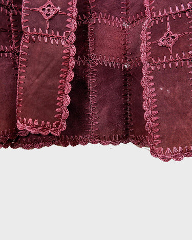 This burgundy leather vest is a vintage gem from the 80s, featuring unique stitching flowers and a boho-style cut. With no closure, it's perfect for layering over any outfit!